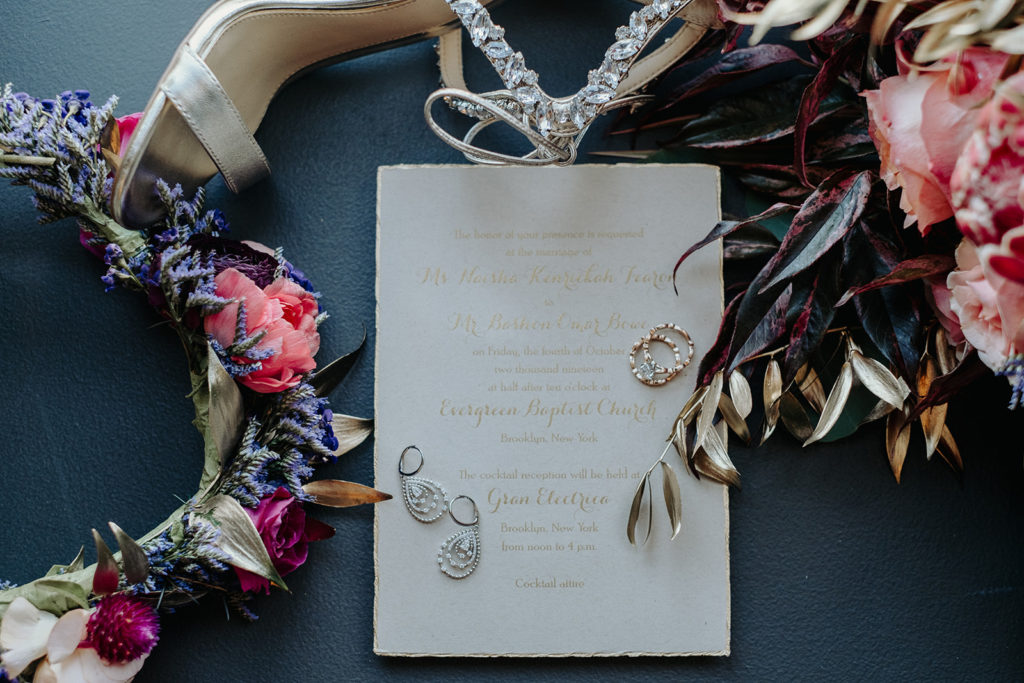 Bridal Details of Flower Crown, Wedding Invitation and bride's wedding band flatlay