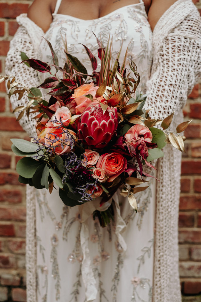 Detail shot of bridal bouquet with proteas and gold in brooklyn bridge park