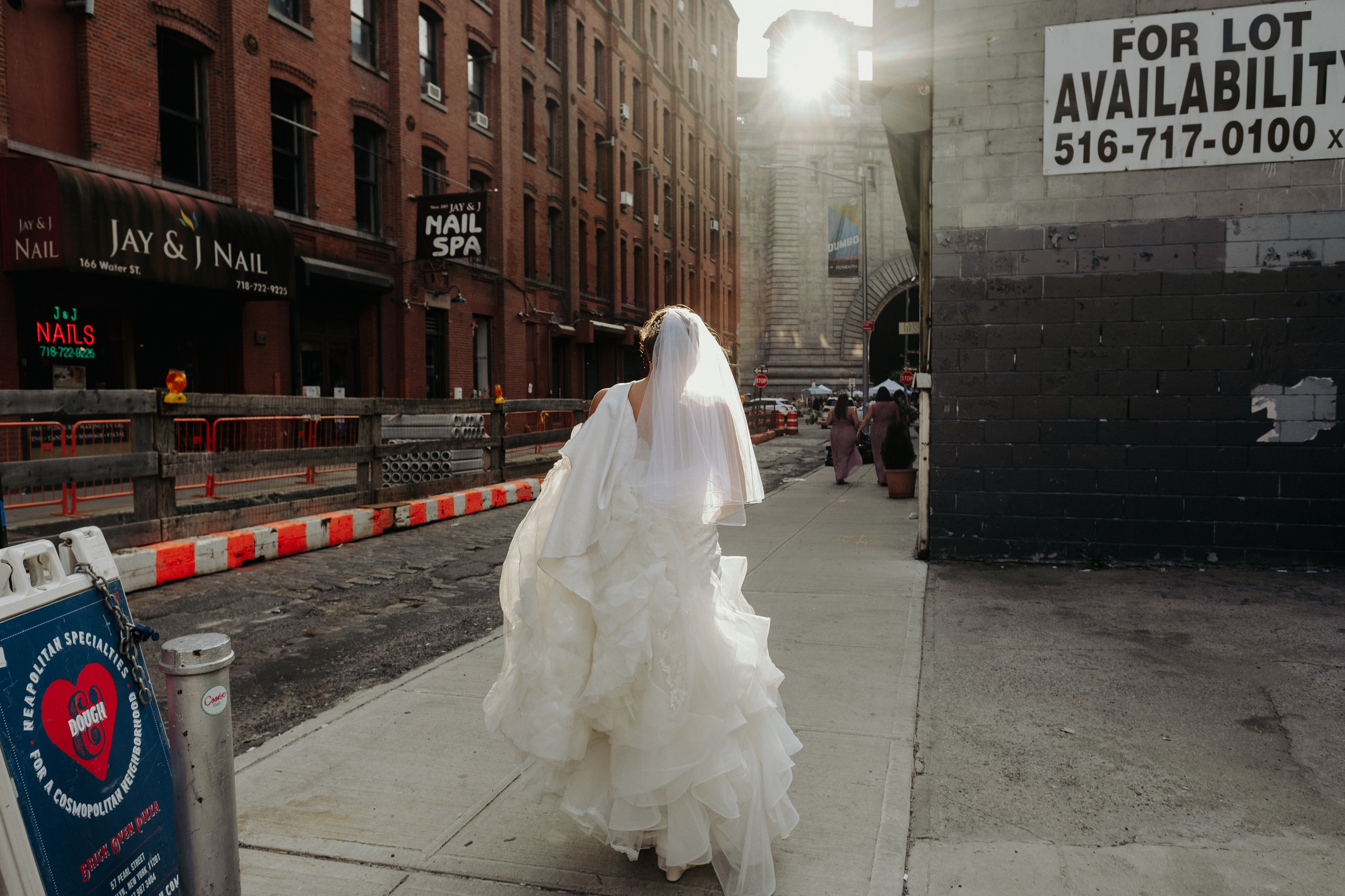 Bride walking through street at sunset in Brooklyn
