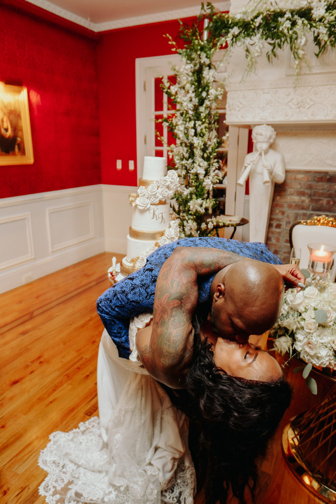 Tattooed Bride wearing calla blanche wedding gown and groom cut cake at James Ward Mansion Wedding