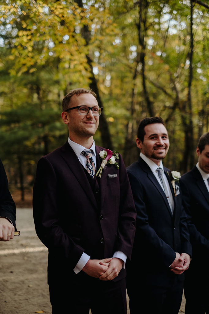 Groom Smiles during Ceremony in Deer Forrest at Southwick's Zoo Mendon