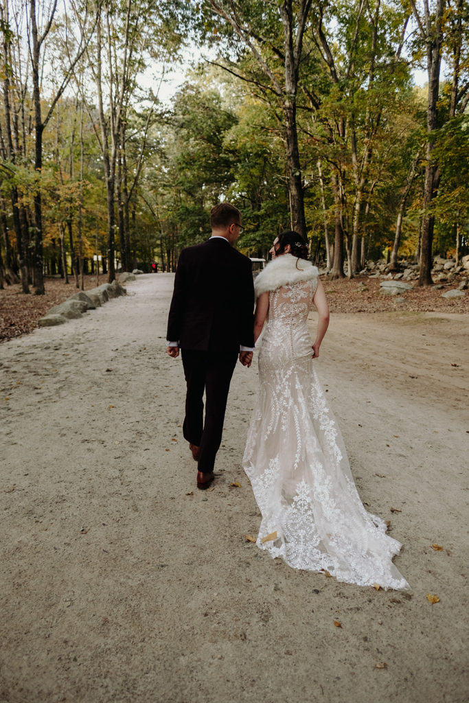 Bride wearing BHLDN and Groom wearing Indochino Suit walking after Ceremony in Deer Forrest at Southwick's Zoo Mendon