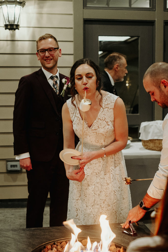 Bride roasts marshmallows during Reception at Southwick's Zoo Mendon MA Wedding