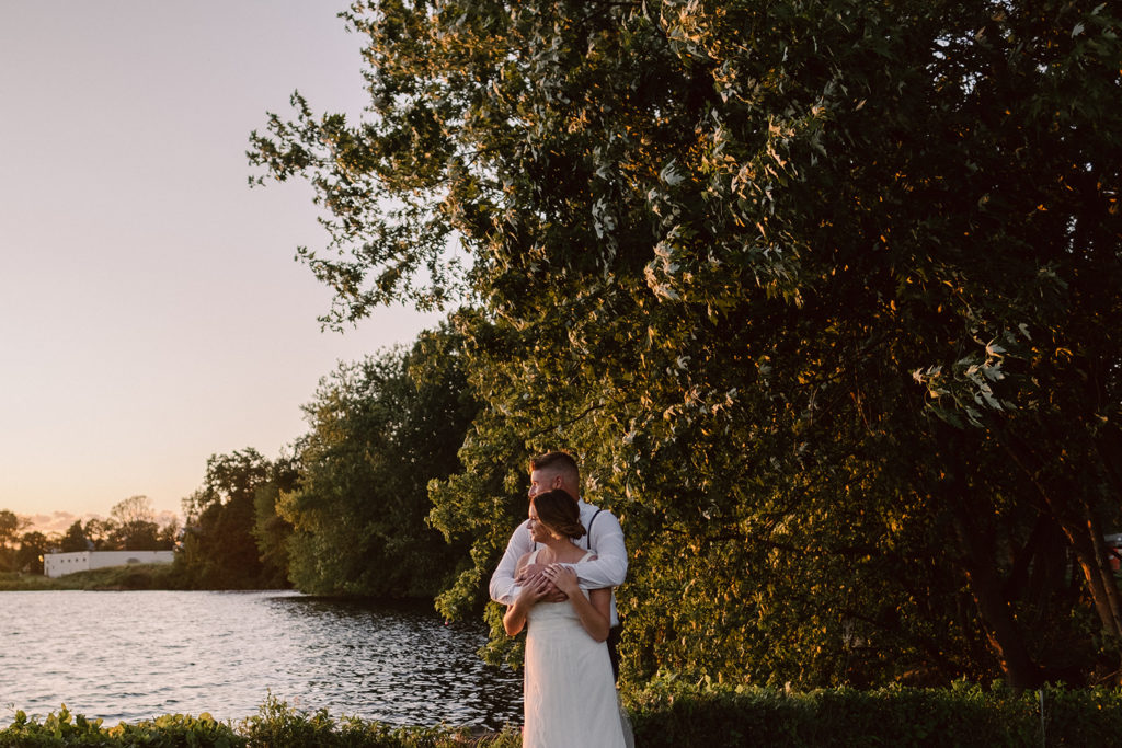 Bride and groom look out onto Lake Ochepee at sunset at Lake Ochepee Inn and Spa during their Elopement