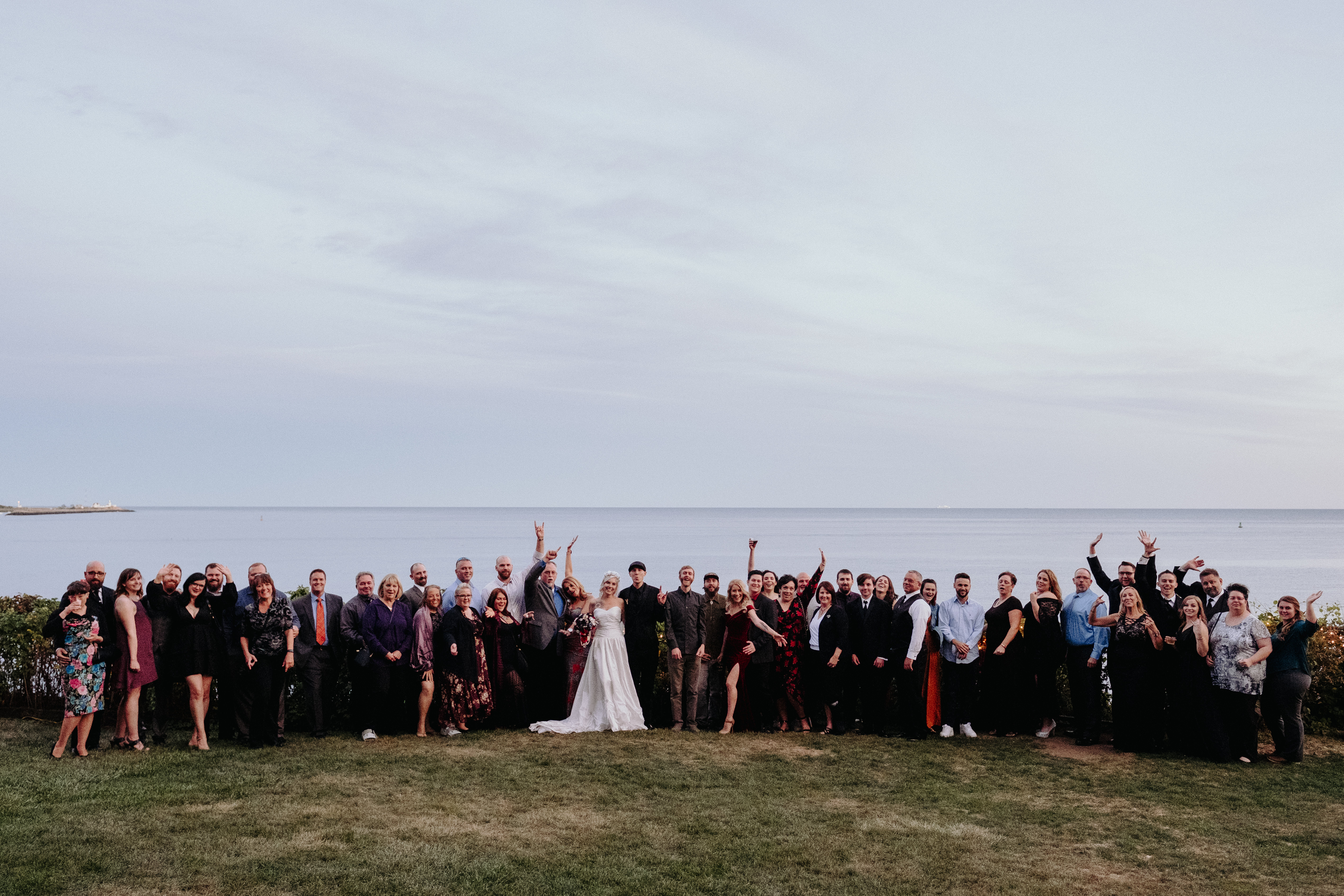 Large group photo of bride and groom with wedding guests at Hammond Castle Museum, Gloucester MA