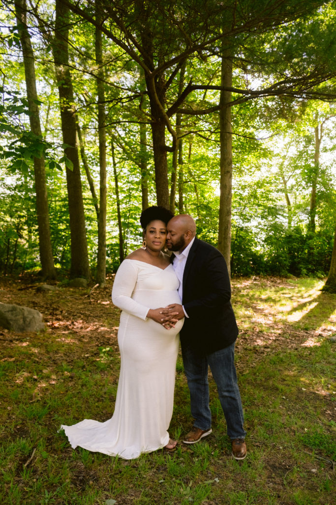 Couple pose together during maternity session at Lincoln Woods state Park