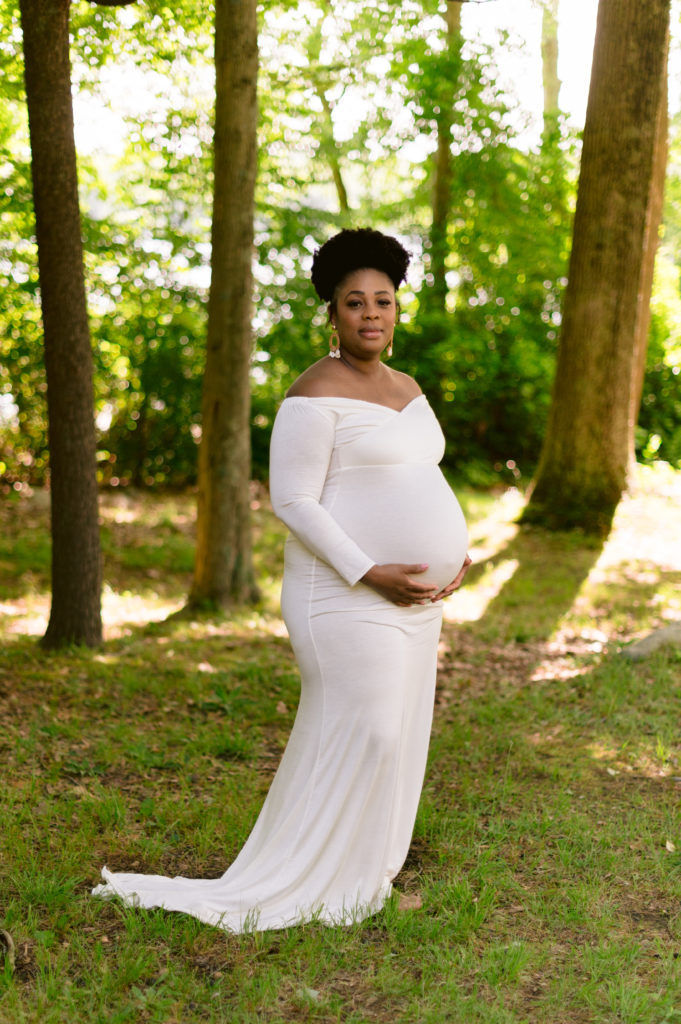 Expectant mother smiles during maternity session in Lincoln Woods state park rhode island