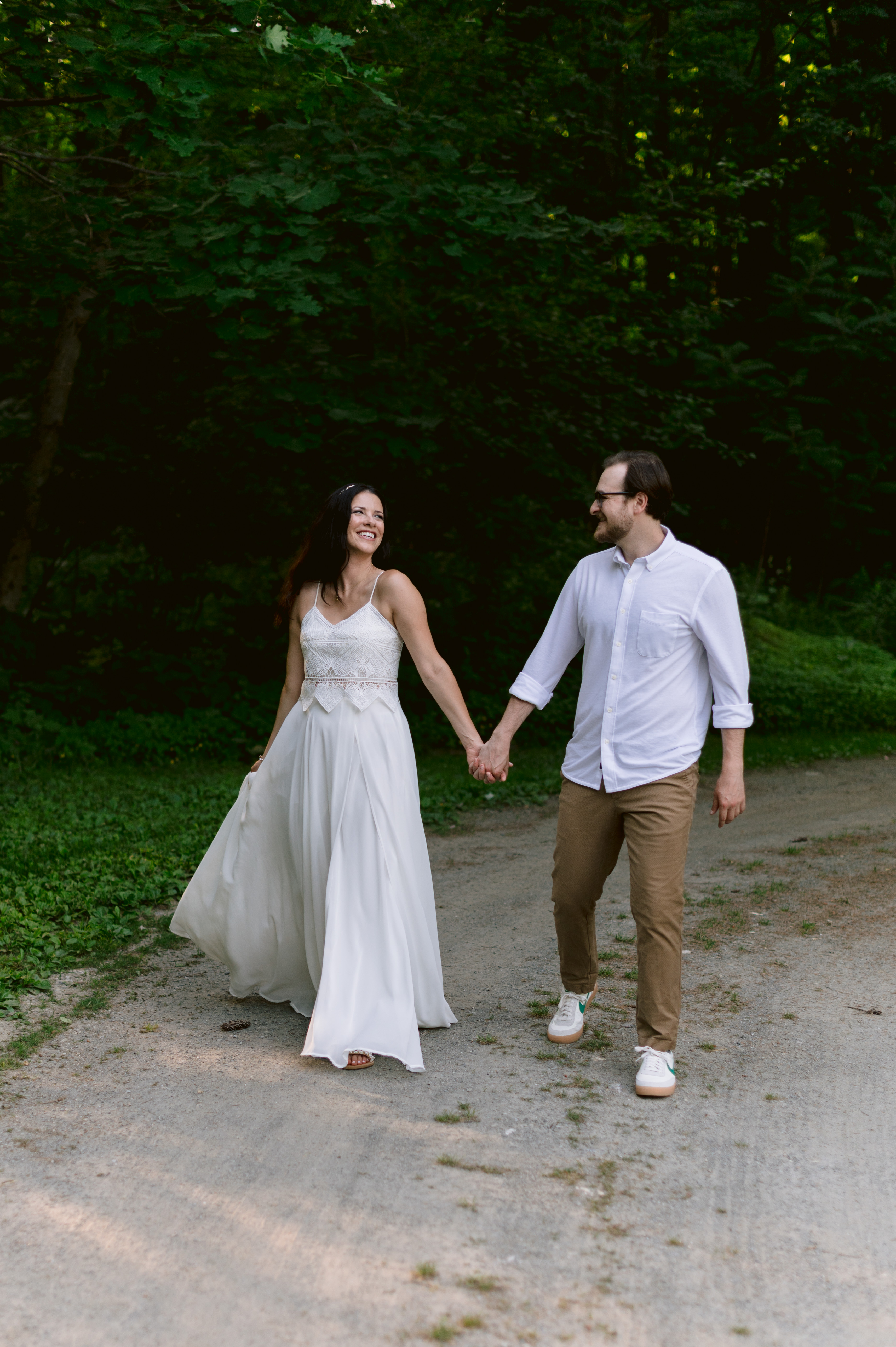 Bride wearing BHLDN dress and groom walk and laugh during Berkshires Elopement
