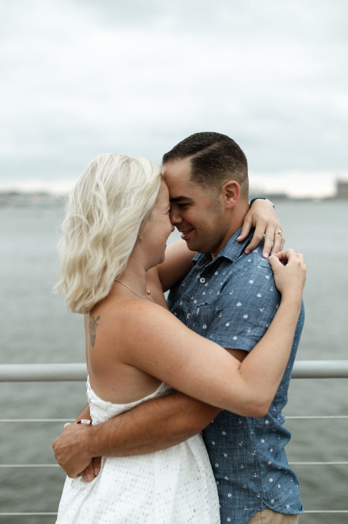 couple along water front in Boston Seaport District during engagement session