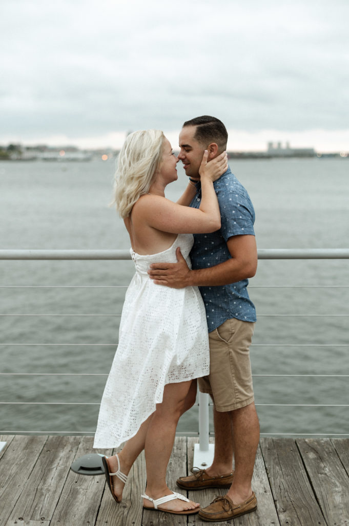 couple along water front in Boston Seaport District during engagement session