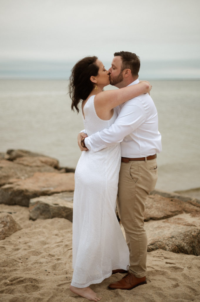 Bride and groom first kiss during their cape cod minimony