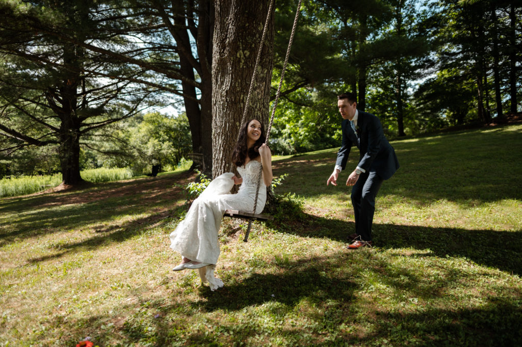 Groom pushes bride on backyard swing during microwedding in Berkshires Upstate New York