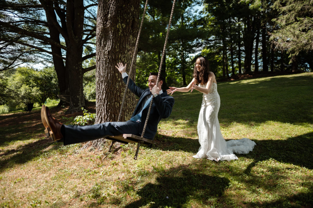 Bride pushes Groom on backyard swing during microwedding in Berkshires Upstate New York