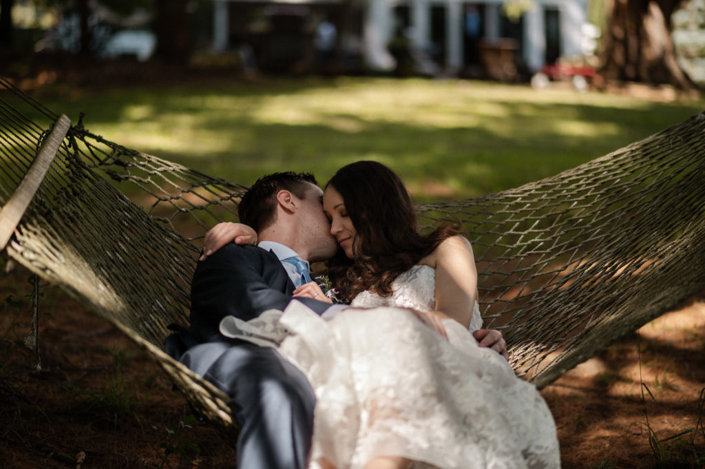 Bride and groom cozy on hammock in Backyard during their upstate new york microwedding in the Berkshires