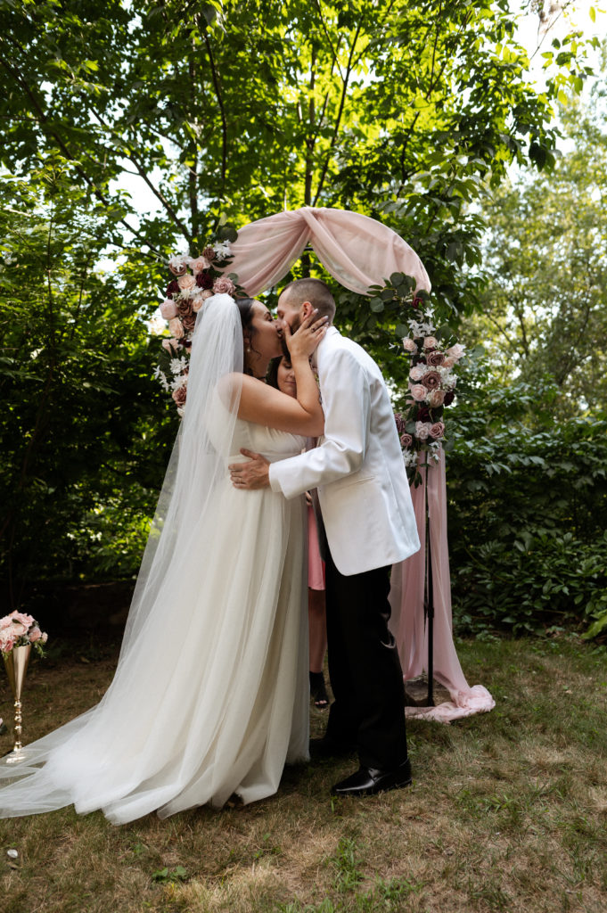Bride and groom share first kiss during ceremony at White Mountains Microwedding