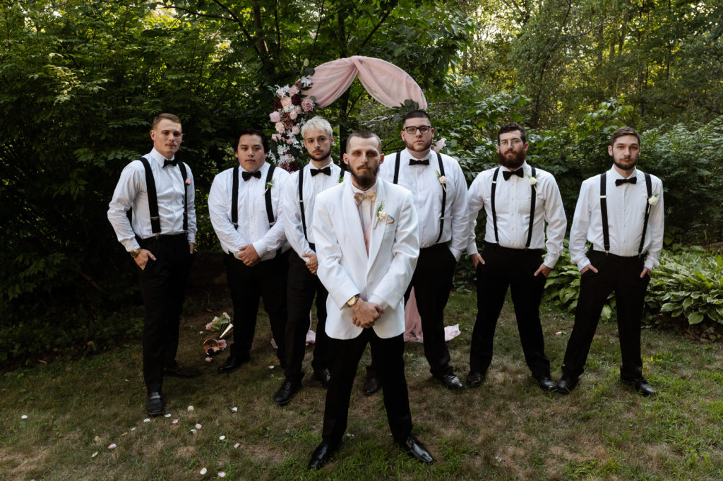 Groom poses with groomsmen during microwedding in New Hampshire White Mountains