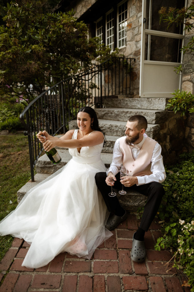 Bride pops champagne with groom at White Mountains New Hampshire Wedding