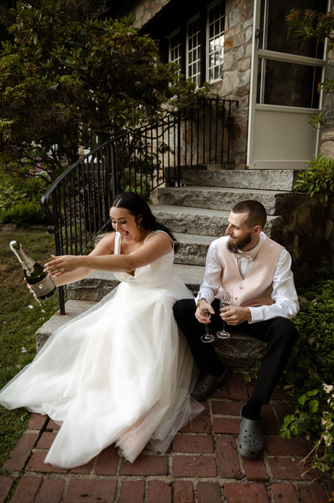 Bride pops champagne with groom at White Mountains New Hampshire Wedding
