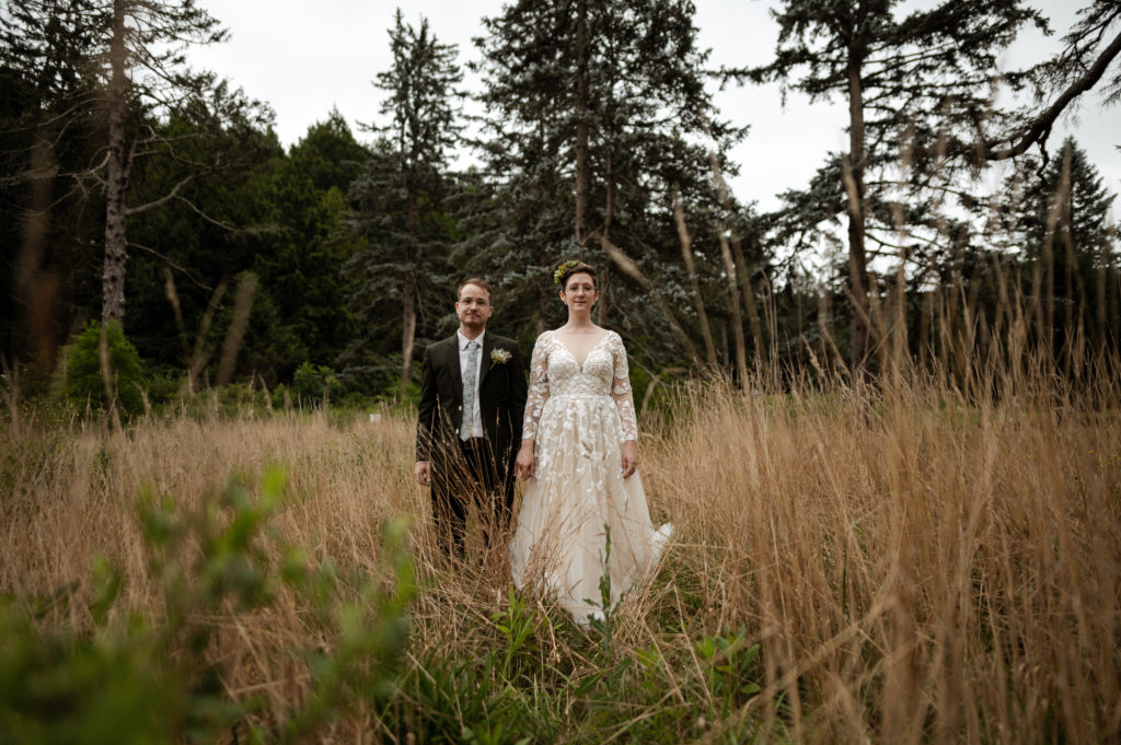 Hipster Bride and groom pose together for portrait in Boston's Arnold Arboretum during their COVID 19 elopement