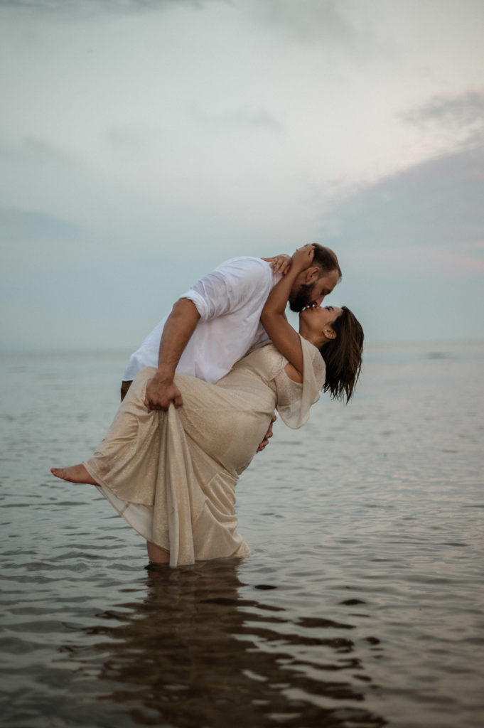 Romantic Sunset anniversary session on Gooseberry Island in Westport Massachusetts, couple in the water with woman wearing BHLDN dress