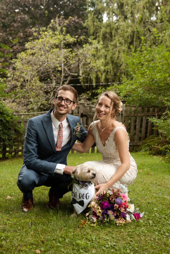Bride and groom post with dog wearing Best Dog Bandana