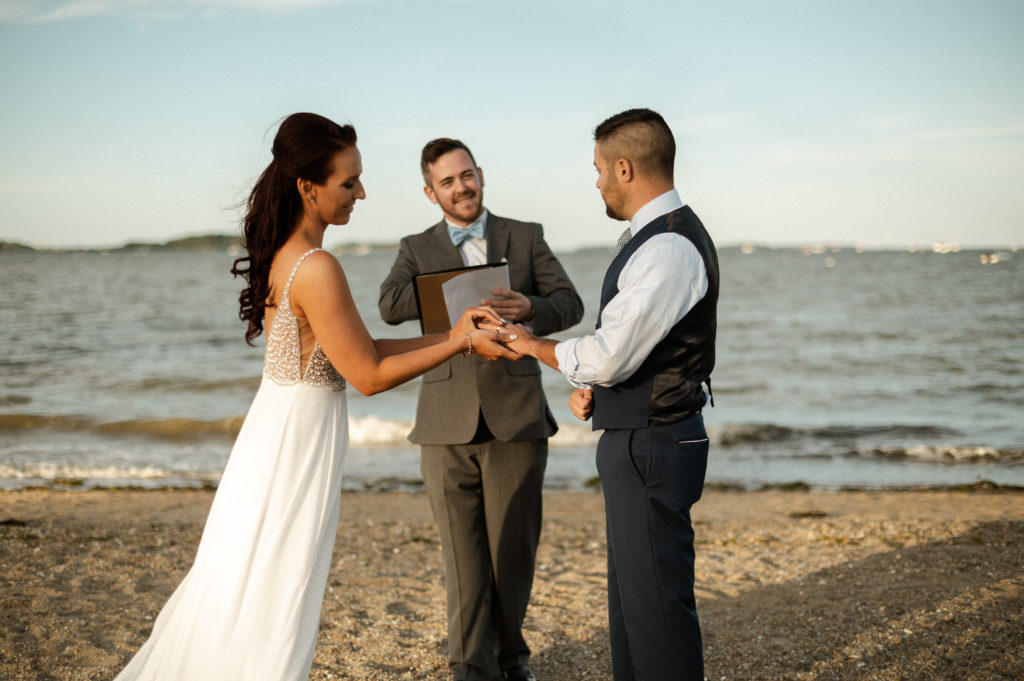 Bride and groom during ceremony on Wollaston Beach Quincy in Boston