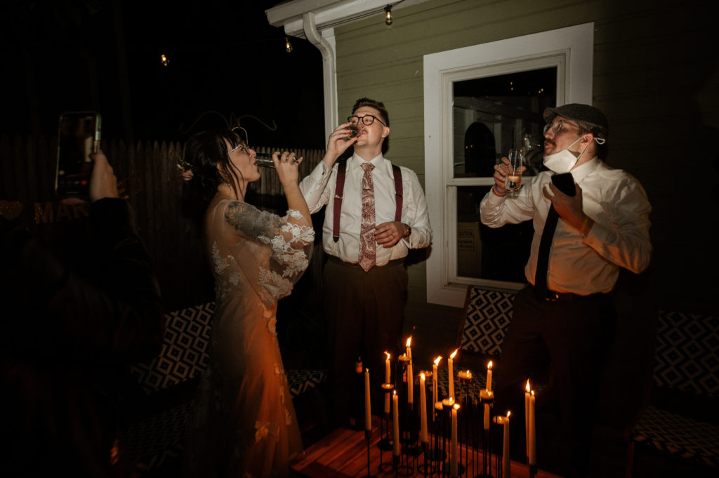 Bride and groom popping champagne bottles together during Boston Elopement