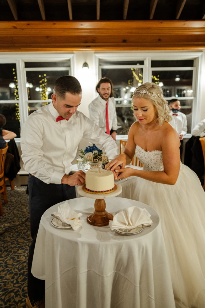 Bride and groom cut cake during reception at the Lighthouse Inn for Cape Cod Wedding