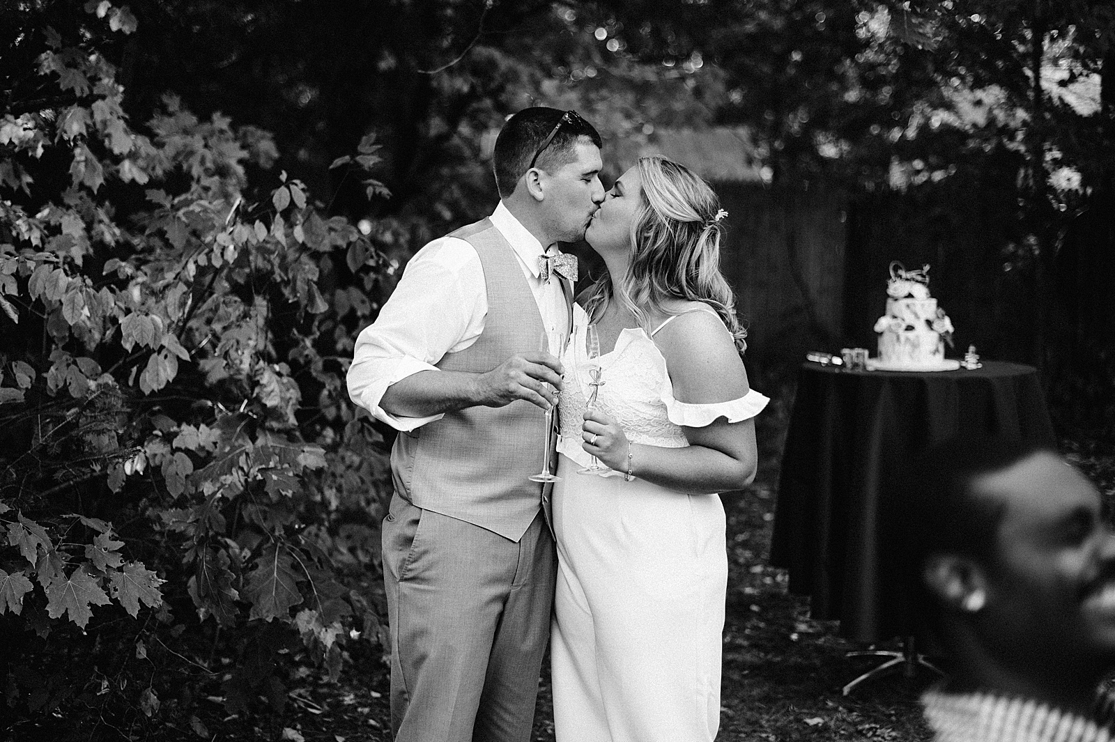 B&W Bride and Groom kissing with champaign glasses