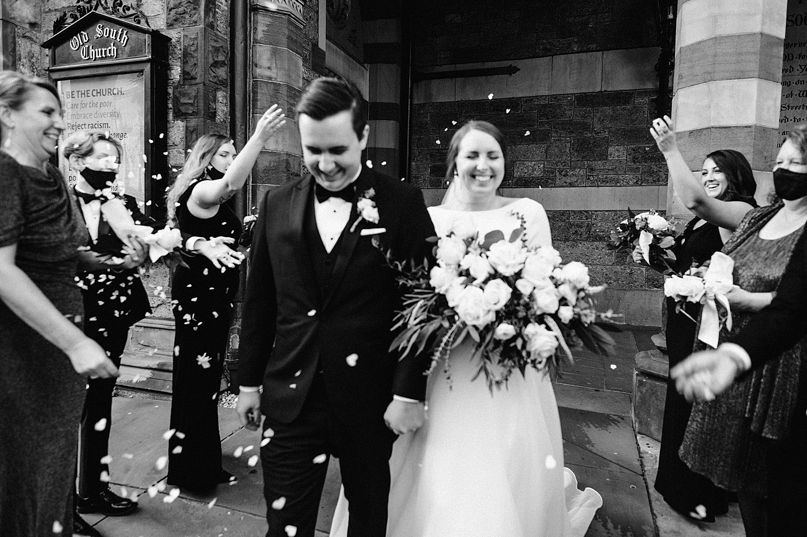 B&W Bride and Groom exiting with Guests throwing flower petals