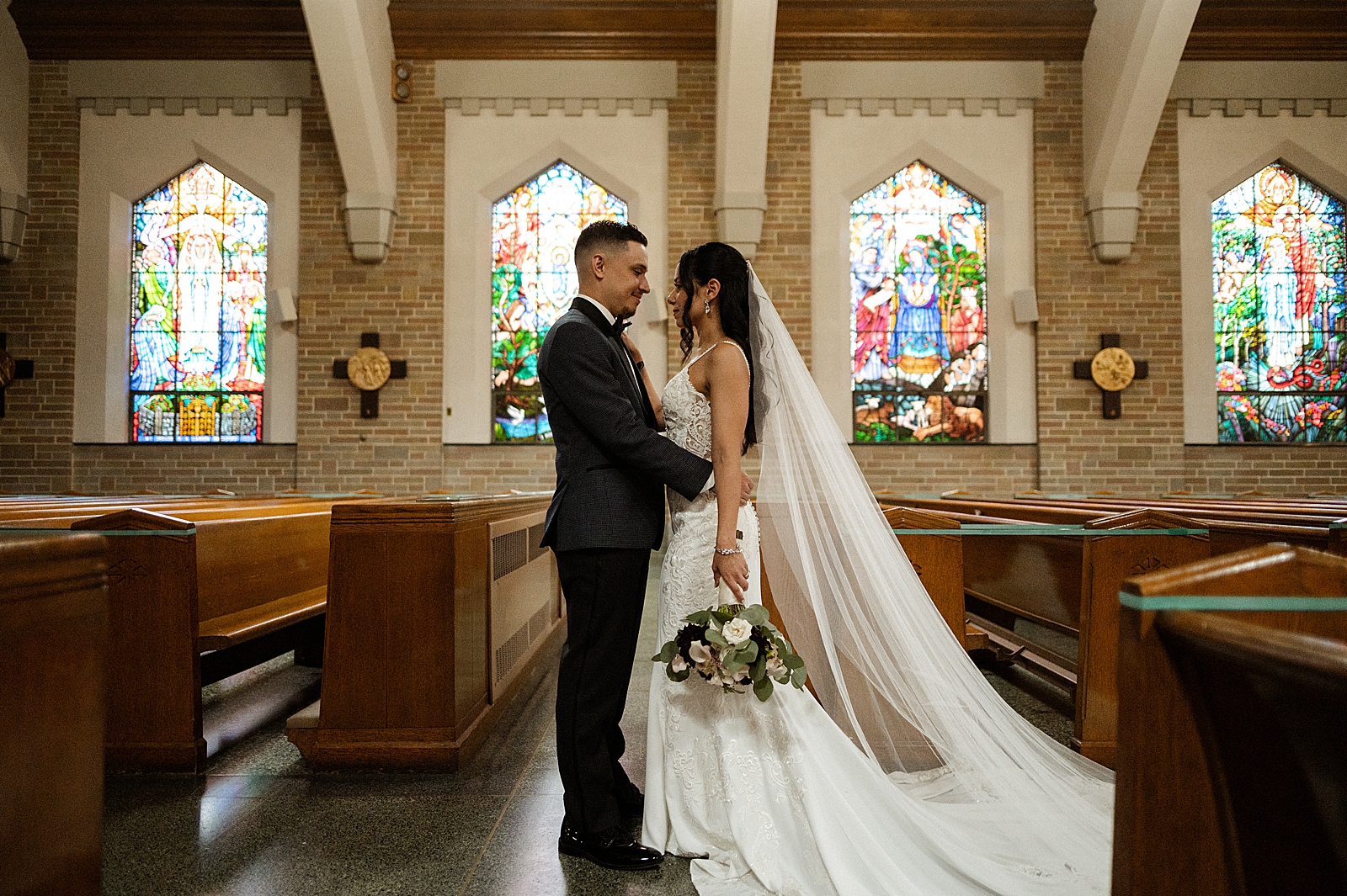 Groom holding Bride close to him in church sanctuary