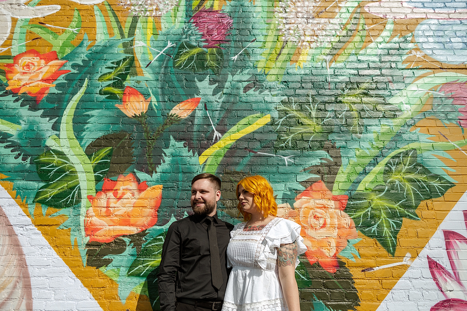 Bride and Groom portrait with arms around each other in front of streetart
