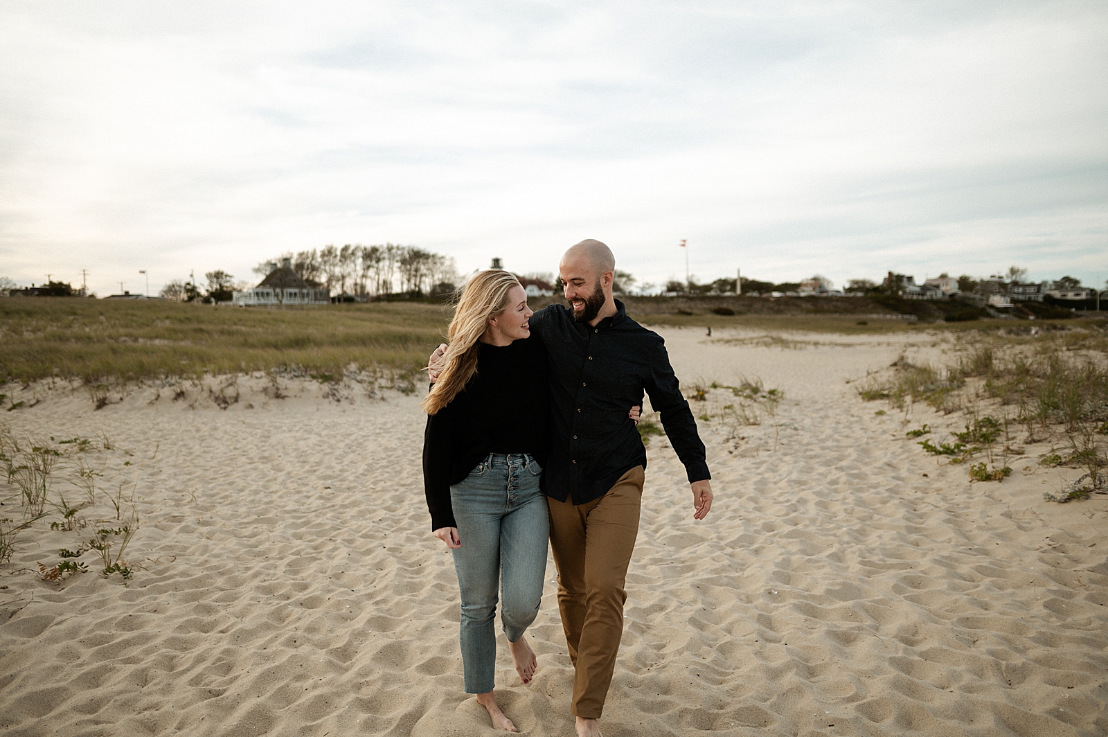 Couple walking on the beach with arms around each other