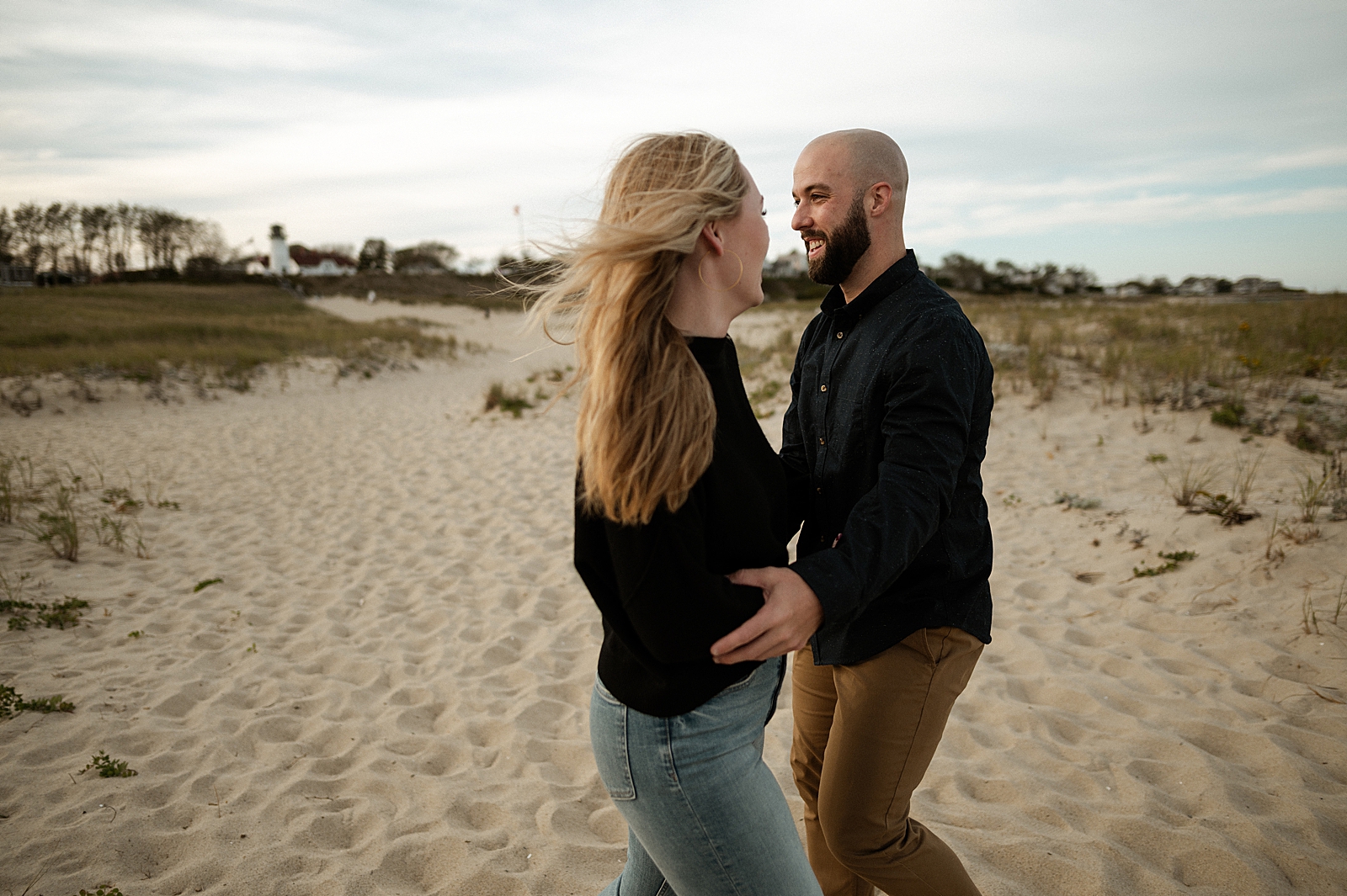 Couple extending their arms to hold each others arms on the beach