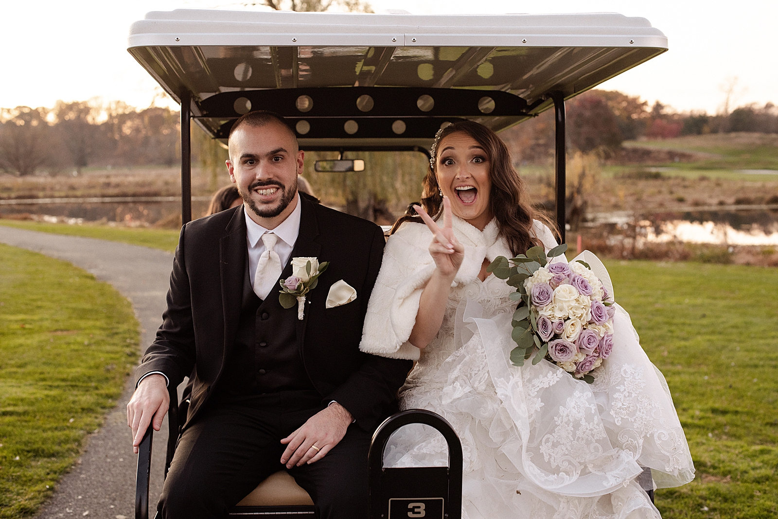 Bride and Groom riding in the back of a golf cart