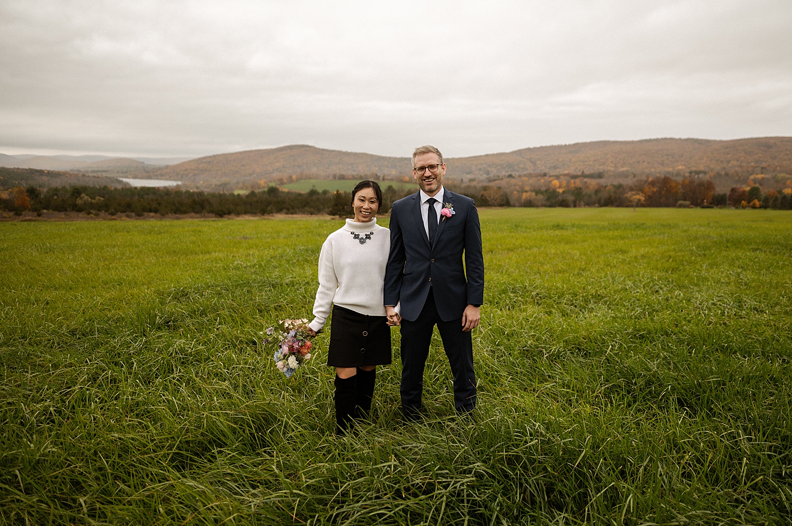 Bride and Groom holding hands on grassy field