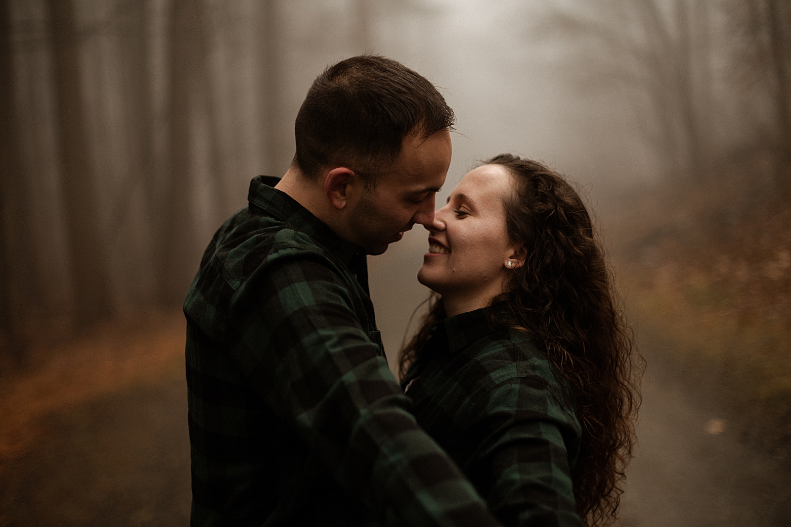 Couple leaning in to kiss in misty area