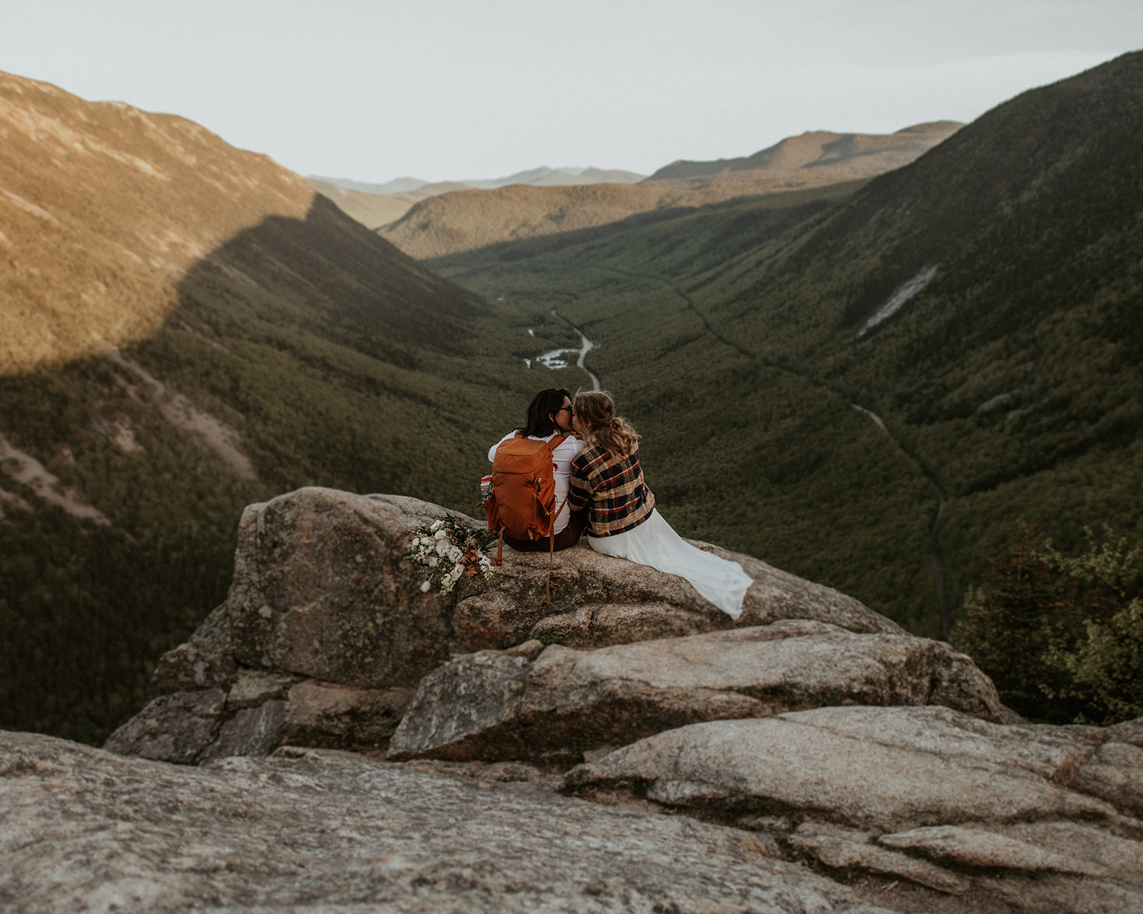 Couple sit together with view of Crawford Notch during their White Mountains Elopement