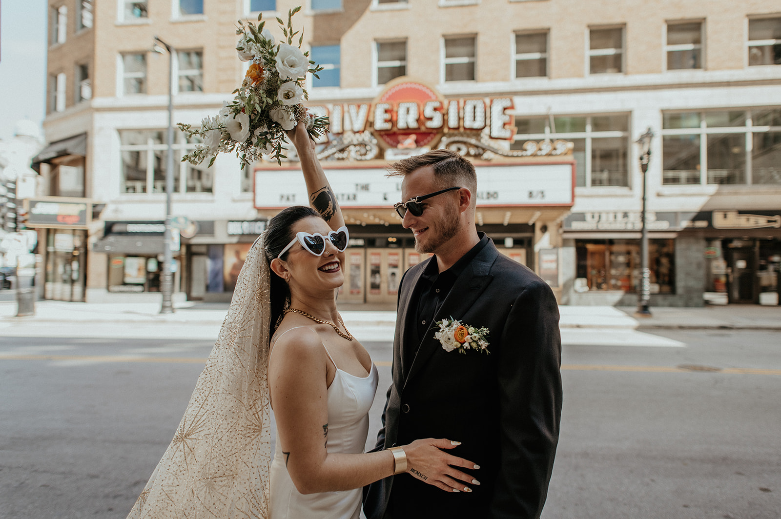 Bride and groom pose in downtown milkwauee wedding wearing sunglasses